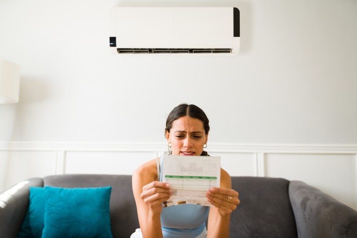 woman looking at energy bill to see if she needs to have her HVAC system serviced