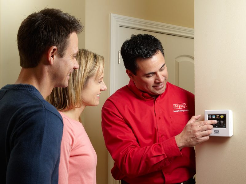 Bryant Tech at thermostat with homeowners